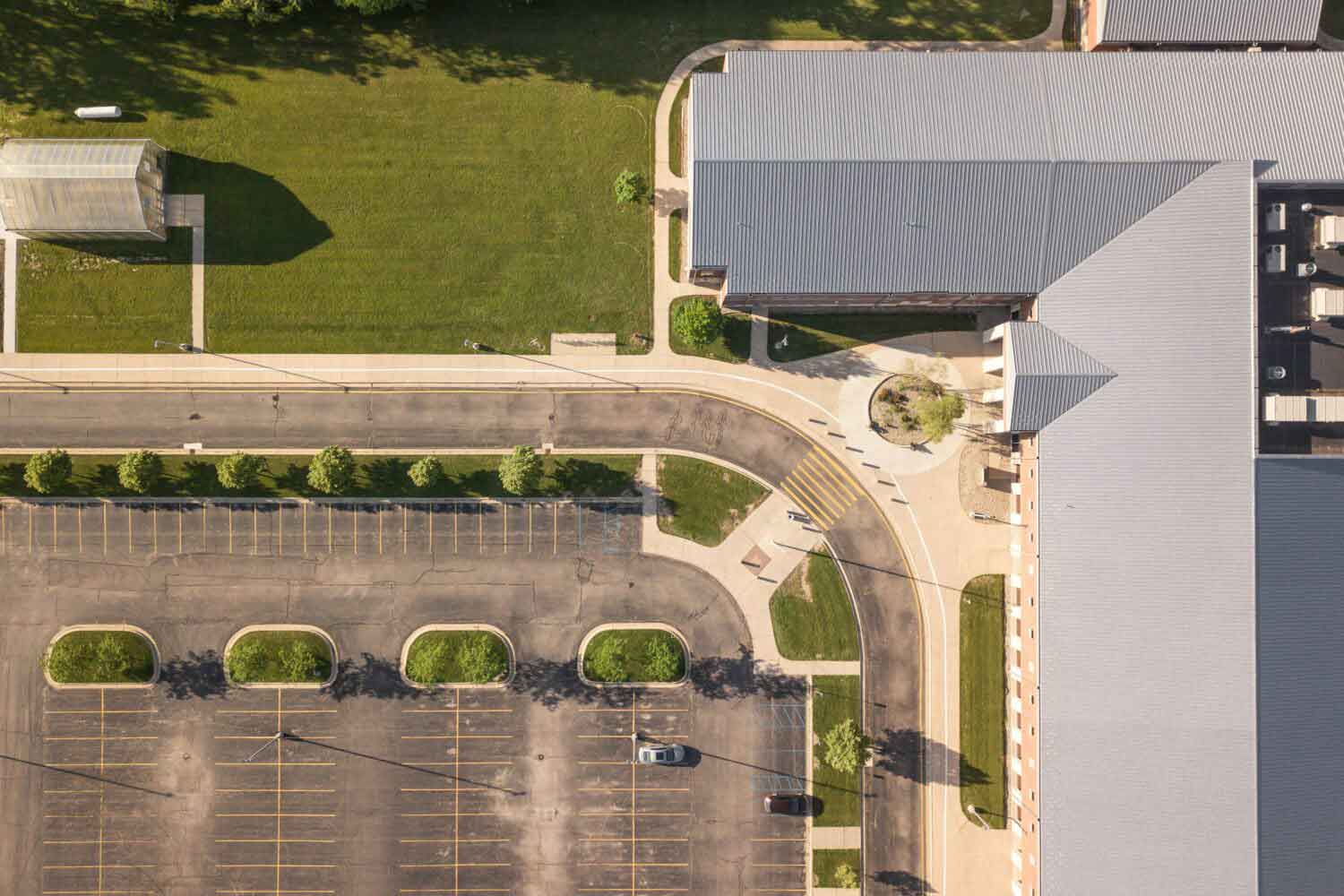 Luftaufnahme von Bürogebäude mit großer Parkfläche